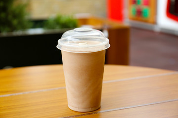 Plastic cup of delicious cool drink on wooden table