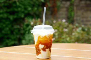 Plastic cup of delicious cool dessert on wooden table