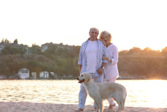 Senior couple and big dog on riverside