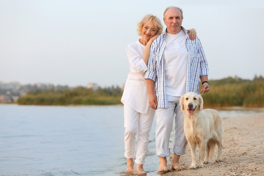 Senior couple and big dog on riverside
