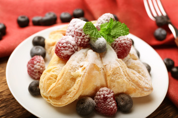 Tasty puff pastry with berries on plate