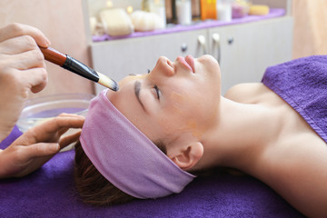 Obraz na płótnie Canvas Young woman having facial care at spa salon