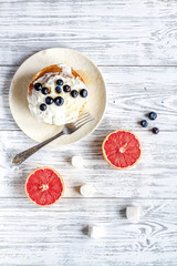 Breakfast concept with flowers on wooden background top view