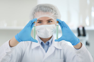 Scientist holding test tubes with samples in laboratory