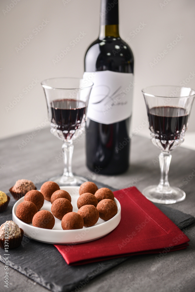 Sticker delicious chocolate truffles and red wine on grey background