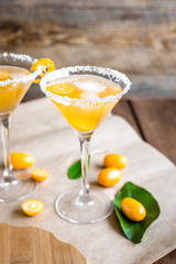 cocktail with kumquat on wooden background