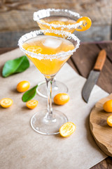 cocktail with kumquat on wooden background