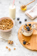 Morning granola with yogurt, honey and berries on white table