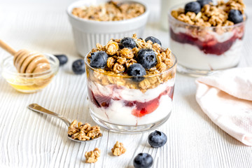 Morning granola with yogurt and berries on white kitchen background