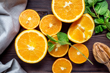 orange juice with mint squeezing on wooden kitchen background top view