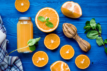 Orange juice in bottle with slices and mint on table top view