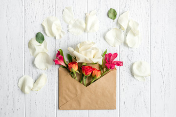 envelope and flowers on wooden background top view mock up