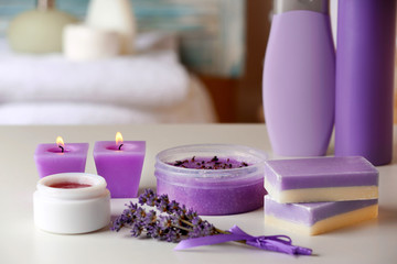 Obraz na płótnie Canvas Set of body care cosmetics with lavender and candles on table