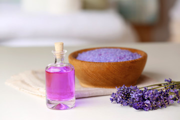 Fototapeta na wymiar Bottle of essential oil with lavender and sea salt on background