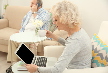 Obraz premium Senior woman making video call using laptop at home