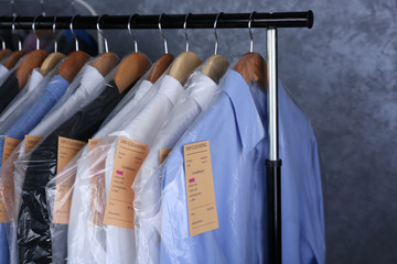 Rack of clean clothes hanging on hangers at dry-cleaning