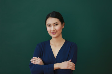 Portrait of Asian female teacher on blackboard background