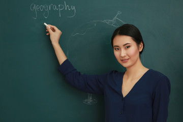 Portrait of Asian female teacher on blackboard background