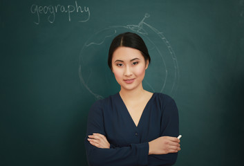 Portrait of Asian female teacher on blackboard background