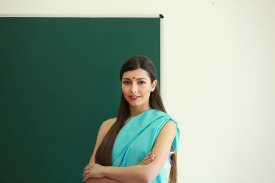 Portrait of Indian female teacher near blackboard in classroom