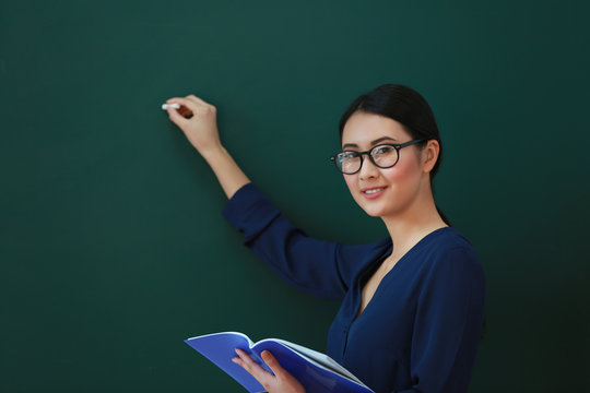 Portrait Of Asian Female Teacher On Blackboard Background