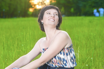 Portrait of Smiling Caucasian Brunette Woman Posing Outdoors on Nature Background.