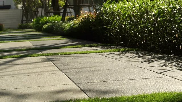 Landscape detail, public paving design with green grass and garden