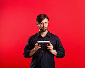 Man holding an empty copyspace. Advertising Space. Attractive man looking at the camera and holding a sign with both hands.