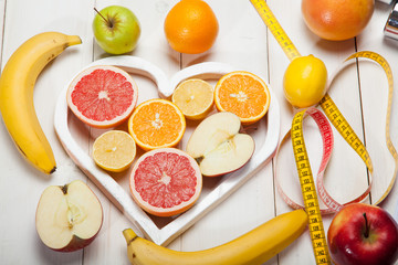 Fruits in heart and centimeter on a white background