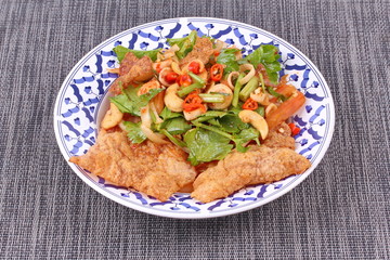 Spicy and sour mixed herb salad with crispy pork served .