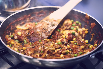 Cooking Pasta Sauce with a wooden spatula in a saucepan on the stove