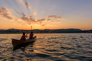 Unidentified traveler boatting in the lake with sunlight