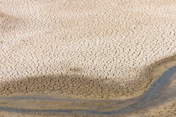 dry riverbed with cracks in earth