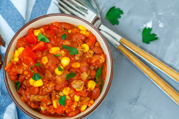Chili con carne in a clay bowl on a concrete background. Traditional Mexican cuisine