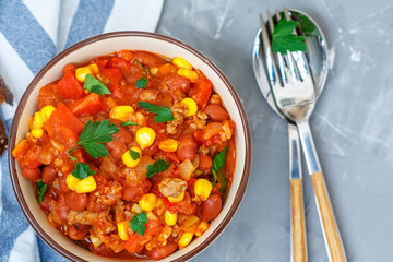 Chili con carne in a clay bowl on a concrete background. Traditional Mexican cuisine