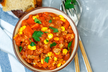 Chili con carne in a clay bowl on a concrete background. Traditional Mexican cuisine