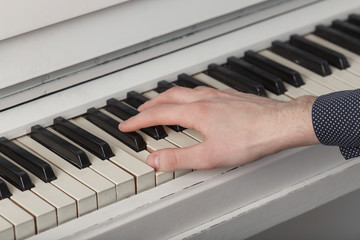 A young man playing piano closeup. © lenblr
