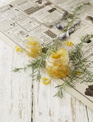 Fototapeta na wymiar orange marmalade in small glass jars with rosemary, selective focus