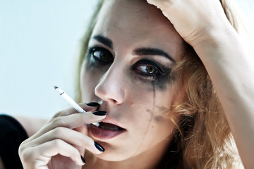 Obraz premium Black and white portrait of pensive young woman smoking