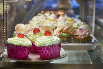 Cupcakes with cream and galcier cherries for sale