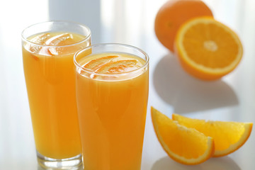 Orange juice with a glass beaker on a glass table