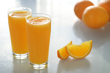 Orange juice with a glass beaker on a glass table