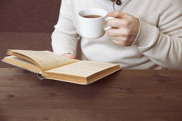 man drinking tea and reading a book
