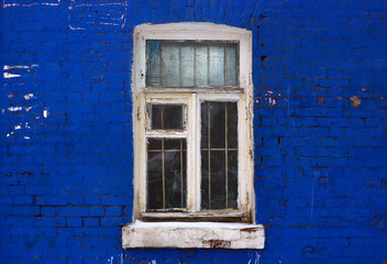 old white window on a background of blue brick wall 