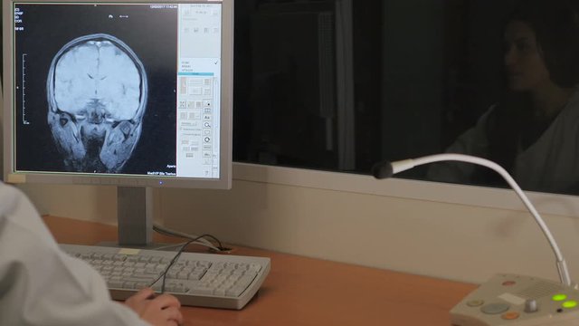 Young girl doing an MRI. Magnetic resonance imaging. Nurse says into the microphone.
