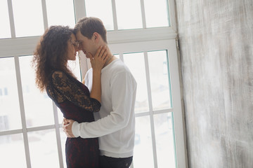 beautiful young couple having a conversation while looking at each other over a window background