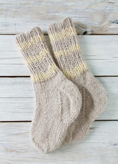 knitted grey socks on wooden surface