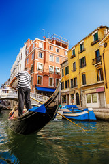 Fototapeta na wymiar Traditional Gondola on a narrow picturesque canal in Venice, Italy