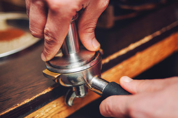 Close-up of a hand pours coffee baristas in the holder.
