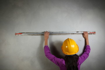 The girl in action of doing plaster work represent the people and construction concept related background.